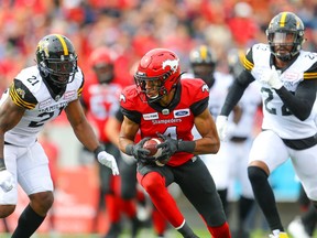 The Calgary Stampeders’ Eric Rogers makes a catch in front of the Hamilton Tiger-Cats’ Simoni Lawrence and Justin Tuggle on Sept. 14, 2019.