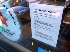 A sign with COVID-19 information is seen on the Cranston Ridge Medical Clinic on Jan. 21, 2021.