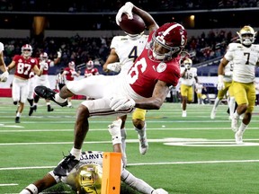 Jan 1, 2021; Arlington, TX, USA;  Alabama wide receiver DeVonta Smith (6) dives over a tackle attempt by Notre Dame safety Shaun Crawford (20) for a touchdown Friday, Jan. 1, 2021 in the College Football Playoff Semifinal hosted by the Rose Bowl in AT&T Stadium. Mandatory Credit: Gary Cosby-USA TODAY Sports     TPX IMAGES OF THE DAY ORG XMIT: IMAGN-440404