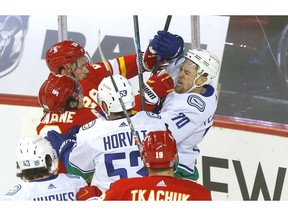 Calgary Flames forward Elias Lindholm battles Vancouver Canucks winger Tanner Pearson in second-period action at the Scotiabank Saddledome in Calgary on Monday, January 18, 2021. Darren Makowichuk/Postmedia