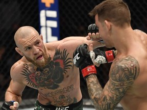 Jan 23, 2021; Abu Dhabi, United Arab Emirates; Conor McGregor of Ireland punches Dustin Poirier in a lightweight fight during the UFC 257 event inside Etihad Arena on UFC Fight Island.  Mandatory Credit: Jeff Bottari/Handout Photo via USA TODAY Sports