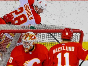 Calgary Flames Elias Lindholm battles for the puck against Carl-Johan Lerby behind goalie Jacob Markstrom during NHL hockey training camp intrasquad game at the Saddledome in Calgary on Thursday January 7, 2021.  Al Charest / Postmedia
