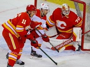 Dominik Simon between Mikael Backlund and goalie Louis Domingue during a Calgary Flames’ intrasquad game at the Saddledome in Calgary on Jan. 11, 2021.