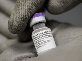A pharmacist holds a vial of frozen Pfizer-BioNTech vaccine in a hospital in Le Mans, France, on Friday, Jan. 15, 2021.