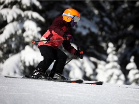 A snowboarder enjoys a beautiful day on the slopes at Mount Norquay.