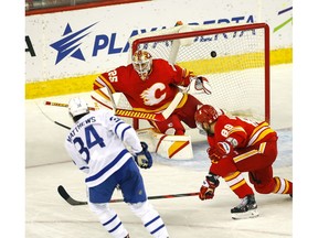 Calgary Flames goalie Jacob Markstrom can't quite make the stop on Toronto Maple Leafs Auston Matthews in first-period action at the Scotiabank Saddledome in Calgary on Tuesday. Photo by Darren Makowichuk/Postmedia.