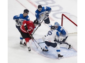 Canada's Connor Zary -- a Calgary Flames prospect -- is on the doorstep of Finland goalie Kari Piiroinen as he is surrounded by Kasper Puutio, Henri Nikkanen and Mikko Kokkenen during IIHF World Junior Hockey Championship action on Thursday in Edmonton. Photo by Greg Southam/Postmedia