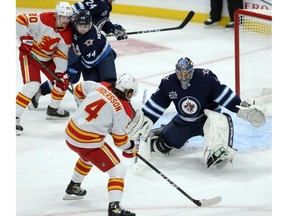Rasmus Andersson drives the net against Jets goalie Connor Hellebuyck during a recent game.