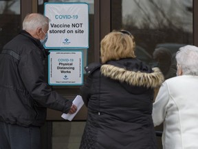 People arrive at the old Greyhound terminal for their COVID-19 vaccination appointment on Friday, Feb. 26, 2021. COVID-19 vaccinations are now available for Albertans 75 and older.