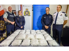 RCMP Corporal Jon Cormier, left, RCMP Inspector Charlene O'Neill, CBSA Officer Shaun Skidmore and CBSA Director Guy Rook pose in front of 50 kg of methamphetamine seized at the Coutts border crossing on Thursday, August 1, 2019.