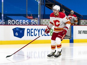 Calgary Flames defenceman Connor Mackey skates by himself as goalie Jacob Markstrom and the team look on prior to Mackey’s first NHL game, on Saturday, Feb. 13, 2021, against the Vancouver Canucks at Rogers Arena in Vancouver.