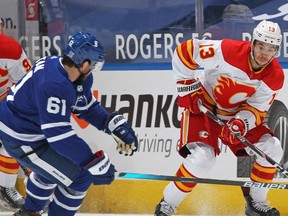 TORONTO, ON - FEBRUARY 22:  Johnny Gaudreau #13 of the Calgary Flames skates with the puck against Nic Petan #61 of the Toronto Maple Leafs during an NHL game at Scotiabank Arena on February 22, 2021 in Toronto, Ontario, Canada.