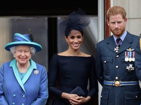 The Queen, Meghan, Duchess of Sussex and Prince Harry, Duke of Sussex, watch the RAF flypast on the balcony of Buckingham Palace, as members of the Royal Family attend events to mark the centenary of the RAF on July 10, 2018 in London.