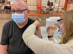 John Lindsay receives his first dose of the COVID-19 vaccine in Medicine Hat on Wednesday, Feb. 24, 2021, as part of the rollout to seniors 75 years and over in Alberta.