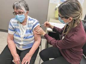 June Churchley, 79, receives the COVID-19 vaccine on Wednesday, Feb. 24, 2021 in Red Deer, Alberta. Churchley was vaccinated as part of the rollout to seniors 75 years and over in Alberta. As of Saturday, Alberta reported 481,771 Albertans had received at least one dose of vaccine.