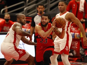 Toronto Raptors guard Fred VanVleet, centre, drives to the basket as Houston Rockets guard Eric Gordon and forward P.J. Tucker defend during the first half at Amalie Arena in Tampa, Fla., Feb. 26, 2021.