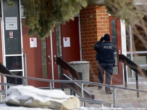 Calgary police investigate a shooting near Forest Lawn High School after two bullets hit the building on Thursday, Feb. 4, 2021. A truck parked in front also was struck.