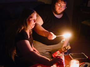 Christina Beverly and John Shearon light candles in their home after winter weather caused electricity blackouts and "boil water" notices in Fort Worth, Texas, Feb. 20, 2021.