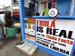 In this file photograph taken on September 30, 2014, Liberians wash their hands next to an Ebola information and sanitation station, raising awareness about the virus in Monrovia.