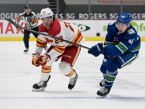 Feb 15, 2021; Vancouver, British Columbia, CAN; Vancouver Canucks defenseman Quinn Hughes (43) checks Calgary Flames forward Dillon Dube (29) in the first period at Rogers Arena.