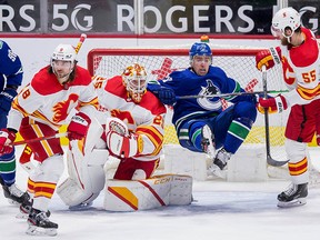 Vancouver Canucks forward Tanner Pearson (No. 70) battles with Calgary Flames defenceman Christopher Tanev (8) and defenseman Noah Hanifin (No. 55) in front of goalie Jacob Markstrom in the second period at Rogers Arena. Bob Frid/USA TODAY Sports