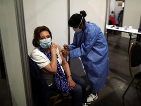 A healthcare worker administers a dose of the Oxford-AstraZeneca coronavirus disease (COVID-19) vaccine, marketed by the Serum Institute of India (SII) as COVISHIELD, to Esther Resmik, 81, at a vaccination centre in Buenos Aires, Argentina Feb. 22, 2021.