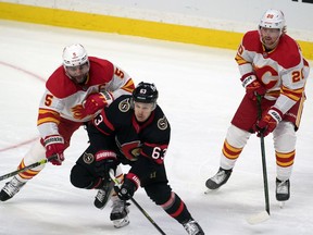 Feb 27, 2021; Ottawa, Ontario, CAN; Ottawa Senators right wing Evgenii Dadonov (63) battles with Calgary Flames defenseman Mark Giordano (5) for control of the puck in the third period at the Canadian Tire Centre. Mandatory Credit: Marc DesRosiers-USA TODAY Sports ORG XMIT: IMAGN-445244