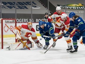 Calgary Flames defencemen Juuso Valimaki and Nikita Nesterov (89) check Vancouver Canucks forwards Tanner Pearson and Adam Gaudette (96) as goalie Jacob Markstrom makes at Rogers Arena in Vancouver on Thursday, Feb. 11, 2021.