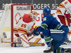 Calgary Flames goaltender Jacob Markstrom makes a save against Vancouver Canucks forward Adam Gaudette at Rogers Arena in Vancouver on Friday, Feb. 13, 2021.