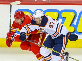 The Calgary Flames’ Mark Giordano is in a foot race with the Edmonton Oilers’ Connor McDavid at the Saddledome in Calgary on Friday, Feb. 19, 2021.