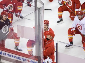 Calgary Flames players listen to head coach Geoff Ward during team practice at the Saddledome earlier this season.