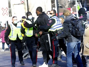 Calgary police were busy keeping the peace as hundreds of anti-mask protesters — some of whom were carrying tiki torches — and counter-demonstrators faced off at City Hall in Calgary on Saturday, Feb. 27, 2021.