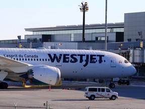 A WestJet Boeing 787 awaits passengers at the Calgary International Airport on Thursday, November 26, 2020.