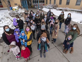 From top left; registered nurses Jenny Kwok, Krissy Rugg with three-weeks-old Miles, Janelle Coady with six-month-old Sophie, Amanda Gillis, Courtney Printz, Ashley Guilbeault with six-month-old Quinn, Patricia Szava-Kovats, Jennifer Bourque, Melissa Reinhart, Briasha Filewich, Kelsey Singer, Erika Haidl with her daughter Eliza, Amanda Lew with three-month-old Aiden, Arden Hicks, Marianne Beier with her daughter Lillian, Christie Emmett, Rebekah Avila with her daughters Harper, three-months-old, and Emma, 2, Courtney Farrow with her son Rogan and her daughter Rachel, Amy Sheldon with seven-month-old Elliot, and Tara Meagher with her daughters Paisley and Summer pose for a photo outside the Foothills Hospital (North Tower) on Thursday, March 25, 2021.
