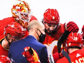 CALGARY, AB - FEBRUARY 9: Assistant coach Ryan Huska of the Calgary Flames talks with Joakim Nordstrom #20, Jacob Markstrom #25, Christopher Tanev #8, Mikael Backlund #11 and Matthew Tkachuk #19 during a time-out in an NHL game against the Winnipeg Jets at Scotiabank Saddledome on February 9, 2021 in Calgary, Alberta, Canada.
