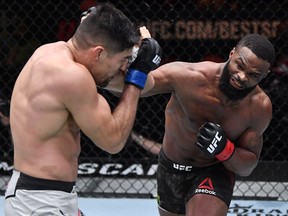 Tyron Woodley punches Vicente Luque in their welterweight fight during UFC 260 at the UFC Apex in Las Vegas on Saturday, March 27, 2021.