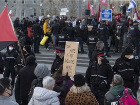 Police line up between counter-protesters and anti-mask protesters during a rally at the Alberta legislature on Feb. 20, 2021.