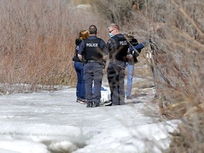 Calgary police investigate after a body was found in the river near Harvie Passage in Calgary on Sunday, March 14, 2021.