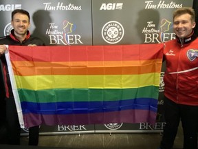 Curlers John Epping (left) and Greg Smith hold a rainbow flag at the 2021 Tim Hortons Brier in Calgary.