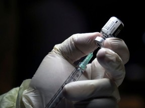 A healthcare worker prepares to administer a Pfizer/BioNTEch coronavirus disease (Covid-19) vaccine at The Michener Institute, in Toronto, Ontario on December 14, 2020.