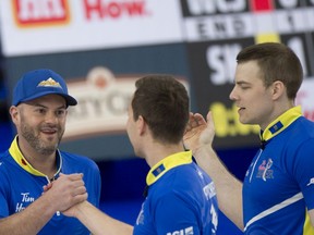 Team Alberta celebrates a razor-thin 8-7 victory over Kevin Koe and Wild Card 2 on Friday at the Brier. From left are: Third Darren Moulding, skip Brendan Bottcher and second Brad Thiessen.