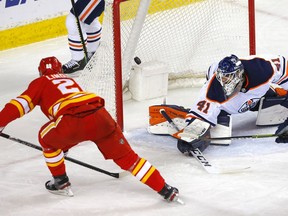 The Calgary Flames’ Elias Lindholm scores on Edmonton Oilers goalie Mike Smith at the Scotiabank Saddledome in Calgary on Monday, March 15, 2021.