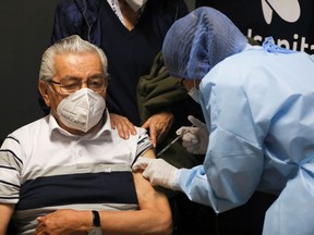 An elderly man receives his first dose of China's Sinovac Biotech vaccine for the coronavirus disease (COVID-19) during the mass vaccination program for the elderly people at Movistar Arena in Bogota, Colombia March 9, 2021.