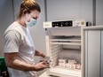 Staff member handles AstraZeneca COVID-19 vaccines in storage at Region Hovedstaden's Vaccine Center, Copenhagen, Denmark February 11, 2021.