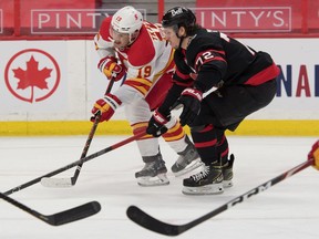 Calgary Flames forward Matthew Tkachuk (19) battles Ottawa Senators defenceman Thomas Chabot at the Canadian Tire Centre in Ottawa on Monday, March 22, 2021.