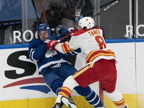 Mar 20, 2021; Toronto, Ontario, CAN; Toronto Maple Leafs center Auston Matthews (34) battles along the boards with Calgary Flames defenseman Christopher Tanev (8) during the first period at Scotiabank Arena. Mandatory Credit: Nick Turchiaro-USA TODAY Sports ORG XMIT: IMAGN-445399