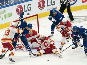 Calgary Flames defenceman Chris Tanev battles with Toronto Maple Leafs forward Auston Matthews in front of goaltender David Rittich at Scotiabank Arena in Toronto on Saturday, March 20, 2021.