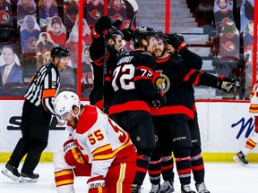 -OTTAWA- March 24,2021. Ottawa Senators congratulate teammate center Chris Tierney (71-smiling) on his game winning goal against the Calgary Flames with Flames defenseman Noah Hanifin (55) looking on in third period NHL action at the Canadian Tire Centre. ERROL MCGIHON/Postmedia