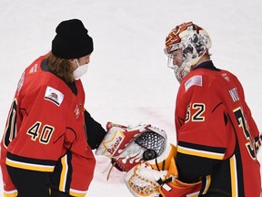 Garret Sparks, left, hands over a keepsake puck to Calgary Flames goaltending prospect Dustin Wolf after the youngster earned his first American Hockey League win on Feb. 24, 2021. Sparks, currently signed to an AHL-only contract with the Stockton Heat, has become both a mentor and buddy to the 19-year-old netminder. (Courtesy of Stockton Heat)