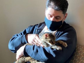 Brandy, a brown tabby cat, on Monday, Feb. 22, 2021, with her owner, Charles at the Palmdale, Calif., animal care centre.